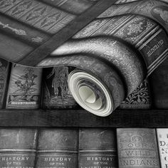 an old book shelf with many books on it and one rolled up in the middle