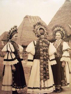 three women in traditional dress standing next to each other with their hands on their hips