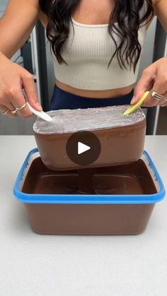 a woman is cutting into a chocolate cake