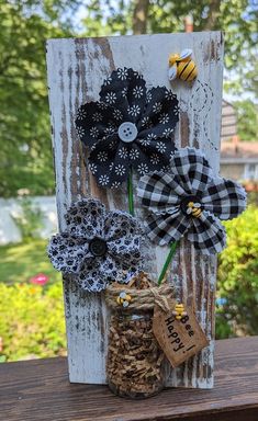 an old door is decorated with black and white paper flowers, burlocked in twine