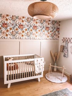 a white crib in a room with floral wallpaper