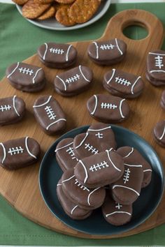 chocolate covered football cookies on a plate with crackers and pretzels in the background