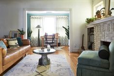 a living room filled with furniture and a fire place under a window next to a fireplace