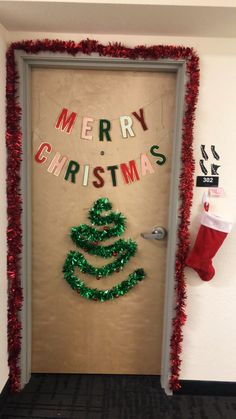 a christmas door decorated with red and green tinsel