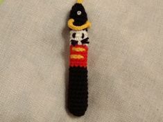 a crocheted keychain with a black and yellow hat on it