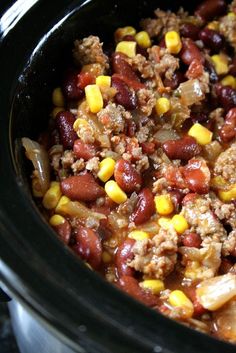 a crock pot filled with chili and corn