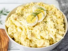 a white bowl filled with mashed potatoes topped with an boiled egg and dill