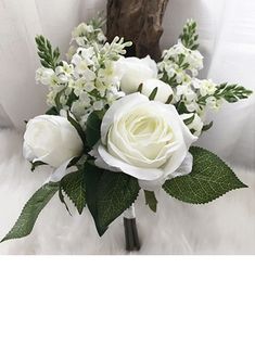 a bouquet of white flowers sitting on top of a bed next to a stuffed animal