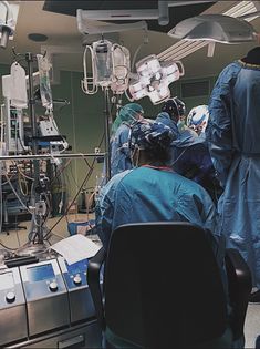 doctors in scrubs and gowns are performing surgery