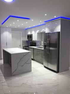 a modern kitchen with marble counter tops and stainless steel refrigerator freezer, stove top oven and microwave