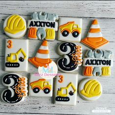 decorated cookies with construction theme are arranged on a table