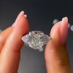 a woman's hand holding a diamond in her left hand, with the center stone missing