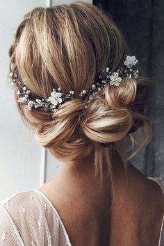 a woman with blonde hair wearing a white dress and a flower headpiece in her hair