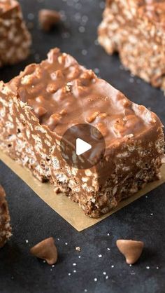 no bake chocolate peanut butter bars on top of a black surface with scattered nuts