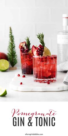 two pomegranate gin and tonic cocktails on a cutting board with rosemary garnish