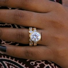 a close up of a person's hand with a diamond ring on their finger