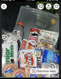 an open lunch box filled with snacks and condiments, including cookies, chips, milk, candy, and more