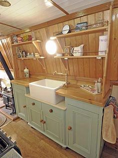 a kitchen with green cabinets and a white sink