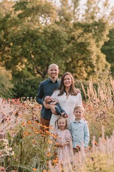 a family standing in the middle of a flower field