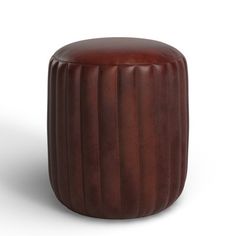 a brown leather stool sitting on top of a white floor