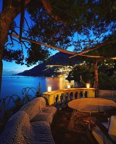 an outdoor seating area overlooking the ocean at night