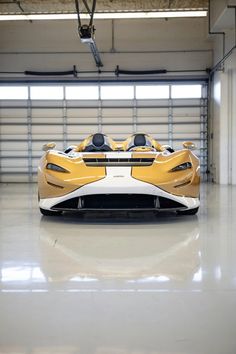 a yellow and white sports car parked in a garage