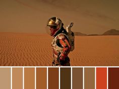 a man in an astronaut suit standing on top of a sandy dune with color swatches