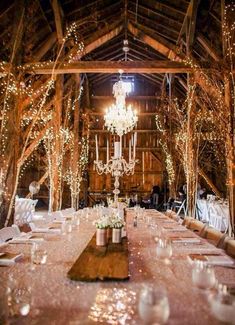 a long table is set up with white linens and candles