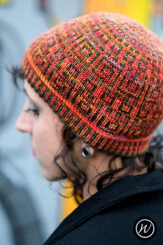 a close up of a person wearing a knitted hat with buttons on the side