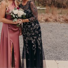 two women standing next to each other in dresses