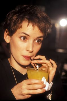 a woman holding a drink in her hand