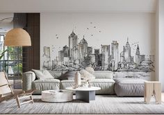 a living room with a couch, chair and table in front of a cityscape wall mural