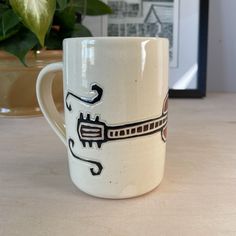 a white coffee mug with a design on it