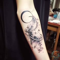 a woman's arm with a crescent and stars tattoo on it