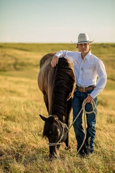 a man standing next to a horse in a field