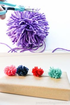 the yarn ball is being used to make pom - poms for hair clips