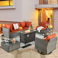 an outdoor living room with wicker furniture and orange cushions on the outside patio area