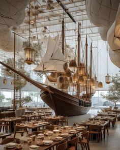 a restaurant with tables, chairs and a large model ship in the middle of it