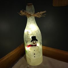 a lighted bottle with a snowman on it