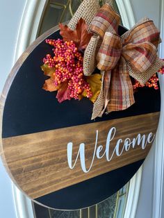 a welcome sign with fall leaves and burlocks on the front door hanger