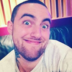 a man sitting on top of a couch with his eyes wide open and looking at the camera