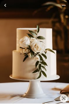 a wedding cake with white flowers and greenery