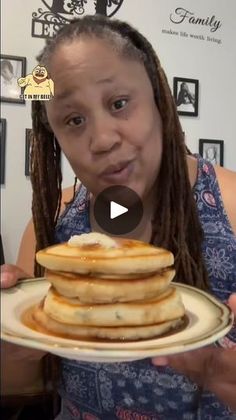 a woman holding a plate with pancakes on it