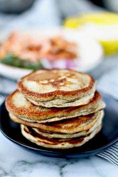 a stack of pancakes sitting on top of a black plate