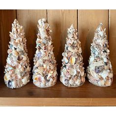 three small trees made out of seashells on a shelf