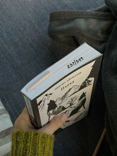 a person holding up a book in their hand