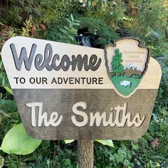 a wooden sign that says welcome to our adventure the smiths in front of some trees