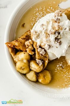 a white plate topped with bananas and ice cream covered in powdered sugar on top of it