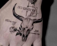 a hand with a tattoo on it that has a bull's skull and name