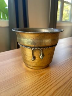 a metal bowl sitting on top of a wooden table